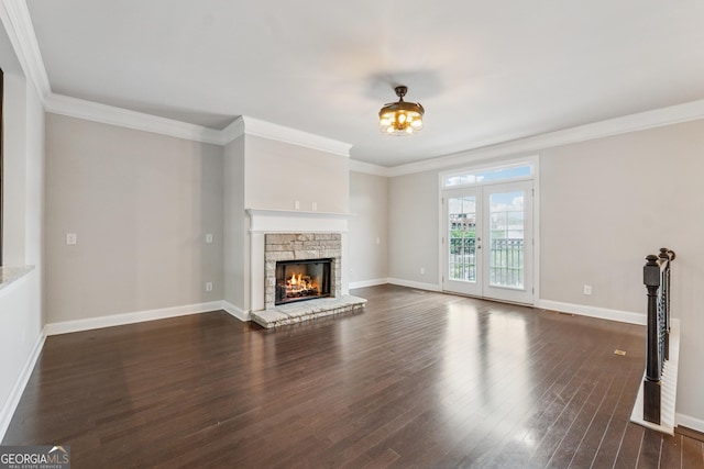 unfurnished living room with dark wood finished floors, baseboards, ornamental molding, and a fireplace