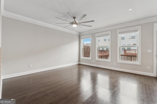 empty room featuring baseboards, dark wood-type flooring, ceiling fan, and crown molding