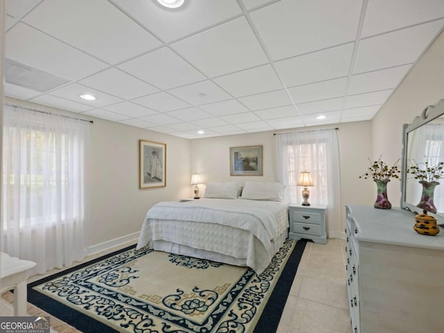 tiled bedroom with multiple windows and a paneled ceiling