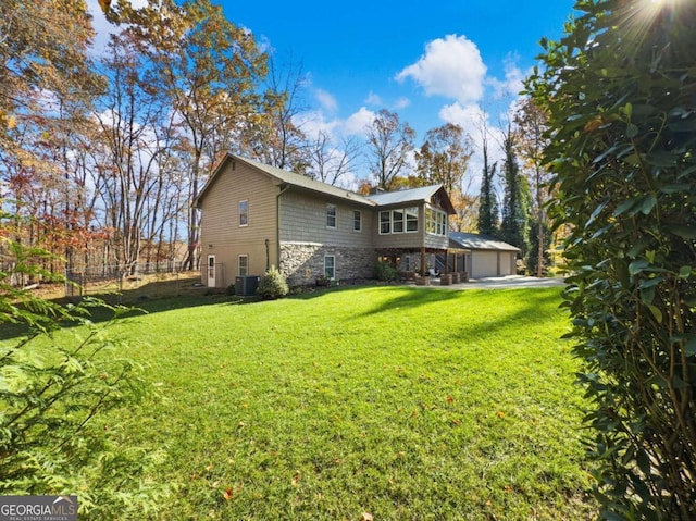 back of property featuring a garage, a yard, and cooling unit