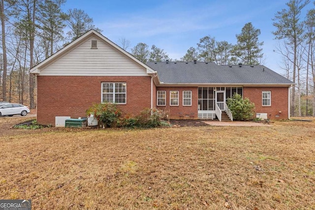 back of house with a sunroom and a lawn