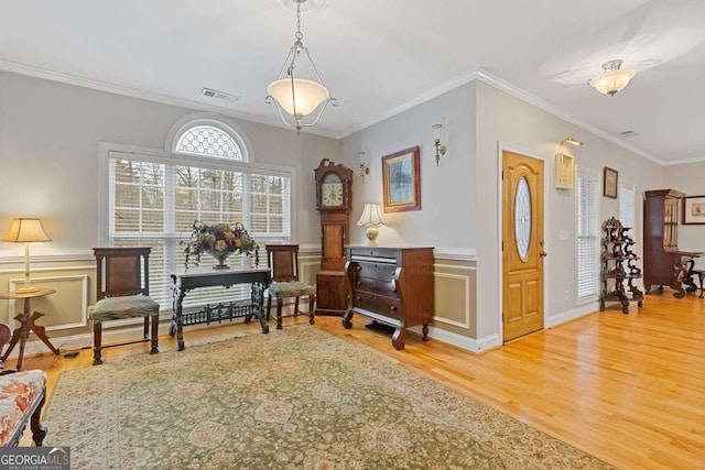 living area with crown molding and wood-type flooring