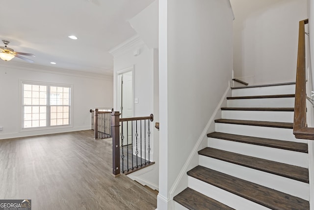 stairway with baseboards, a ceiling fan, wood finished floors, crown molding, and recessed lighting