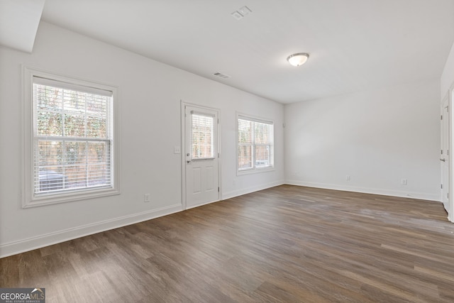 entryway with dark wood-style floors, visible vents, and baseboards