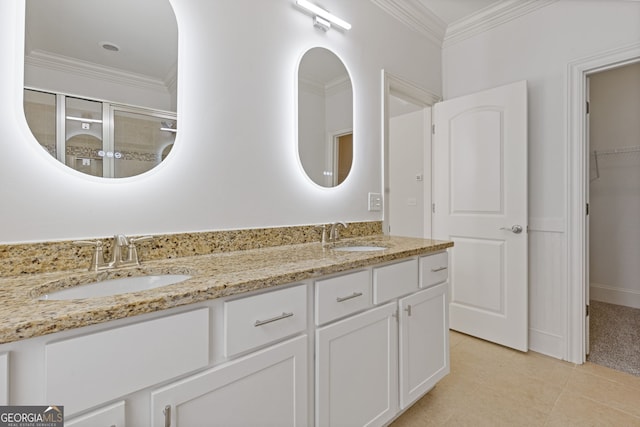 bathroom with double vanity, ornamental molding, a stall shower, and a sink