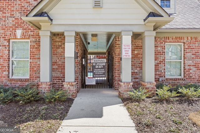 view of exterior entry featuring brick siding