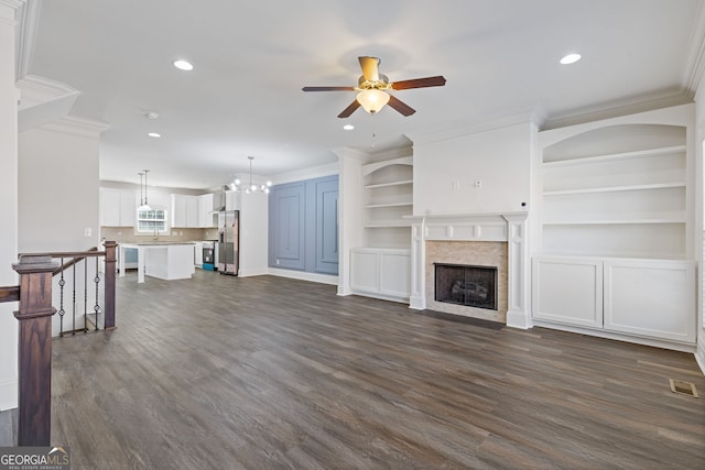 unfurnished living room with recessed lighting, dark wood-style flooring, a premium fireplace, visible vents, and ornamental molding