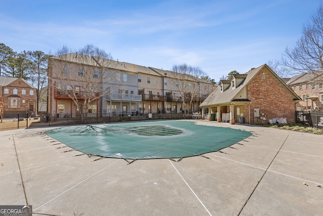 pool with a patio area and fence