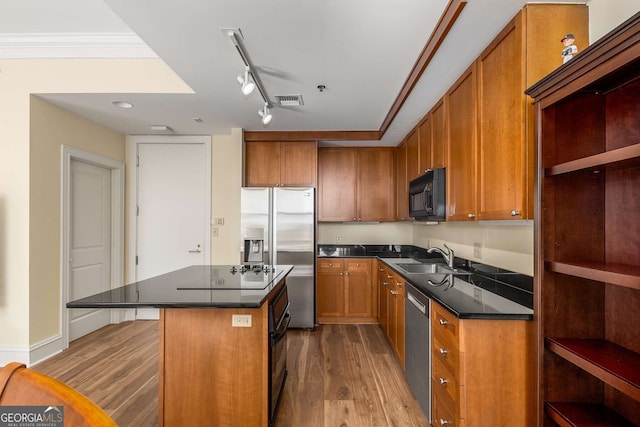 kitchen featuring hardwood / wood-style flooring, a center island, sink, and black appliances