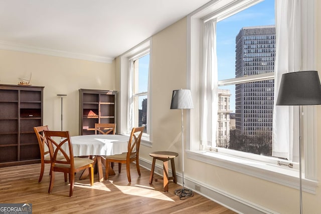 dining room with hardwood / wood-style flooring and ornamental molding