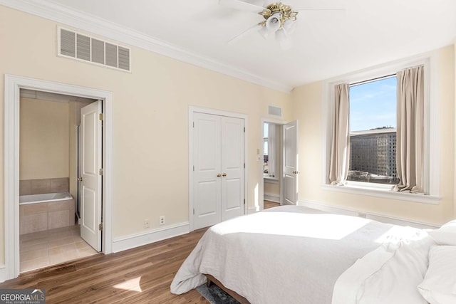 bedroom with ensuite bath, wood-type flooring, ornamental molding, a closet, and ceiling fan