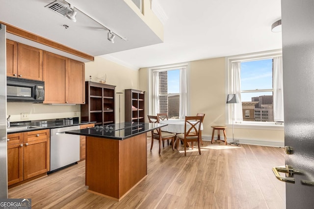 kitchen with crown molding, a center island, light hardwood / wood-style flooring, track lighting, and black appliances