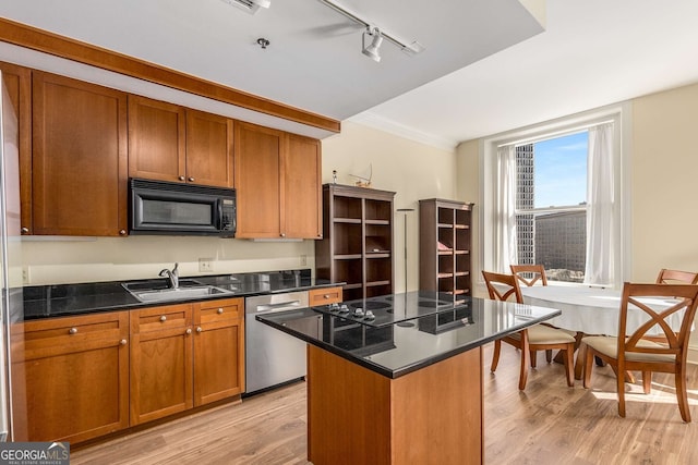 kitchen with a kitchen island, sink, light hardwood / wood-style flooring, and black appliances