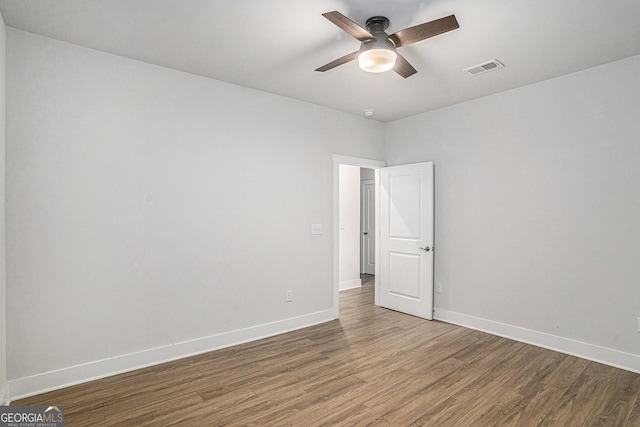 empty room with ceiling fan and dark hardwood / wood-style floors