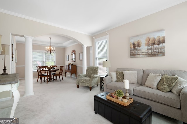 living room featuring crown molding, carpet floors, a chandelier, and decorative columns