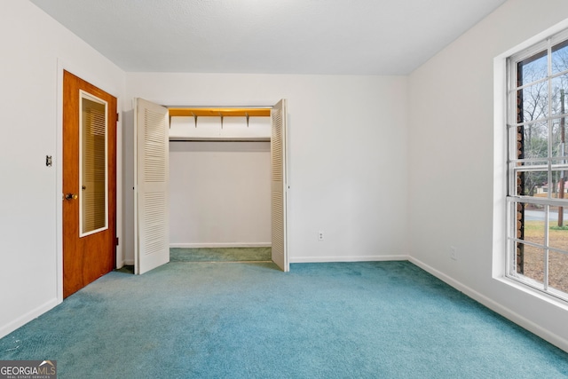 unfurnished bedroom featuring light carpet and a closet