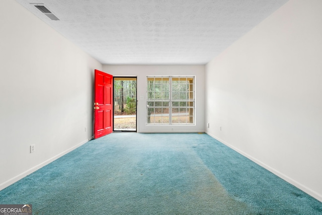 carpeted spare room with a textured ceiling