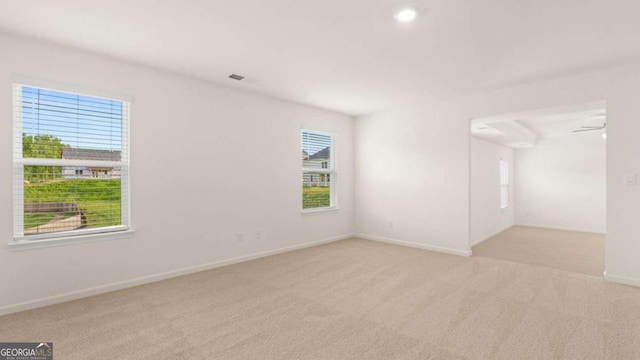 carpeted spare room featuring plenty of natural light