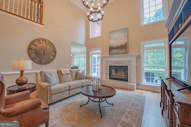 living room featuring a healthy amount of sunlight, an inviting chandelier, and light hardwood / wood-style floors