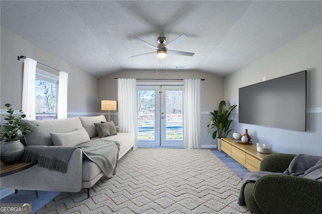 living room featuring vaulted ceiling, a wealth of natural light, ceiling fan, and a textured ceiling