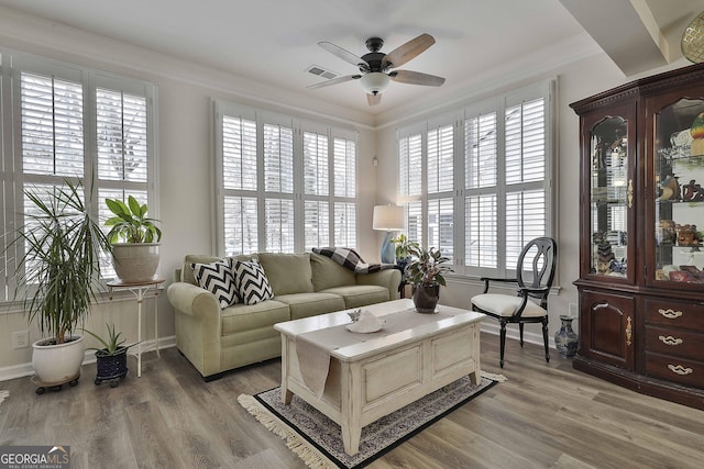 living room featuring crown molding, hardwood / wood-style floors, and ceiling fan