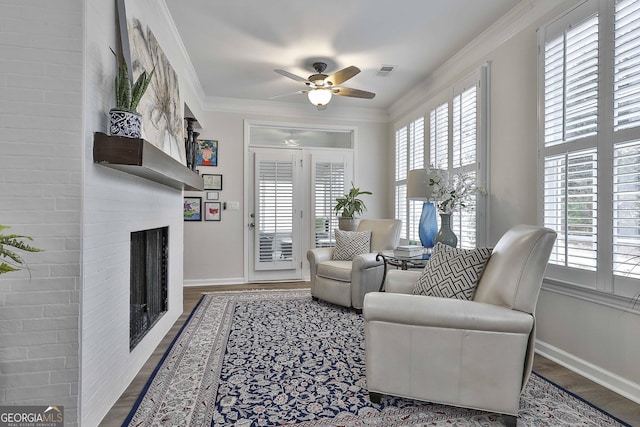 living area featuring hardwood / wood-style floors, ornamental molding, and ceiling fan