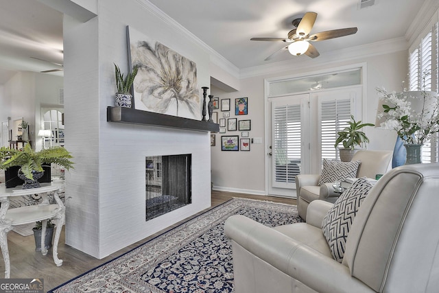 living room with crown molding, a multi sided fireplace, and wood-type flooring