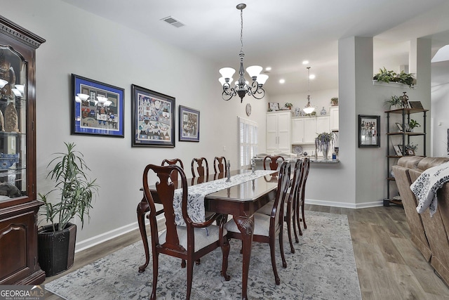 dining area with a notable chandelier and light wood-type flooring