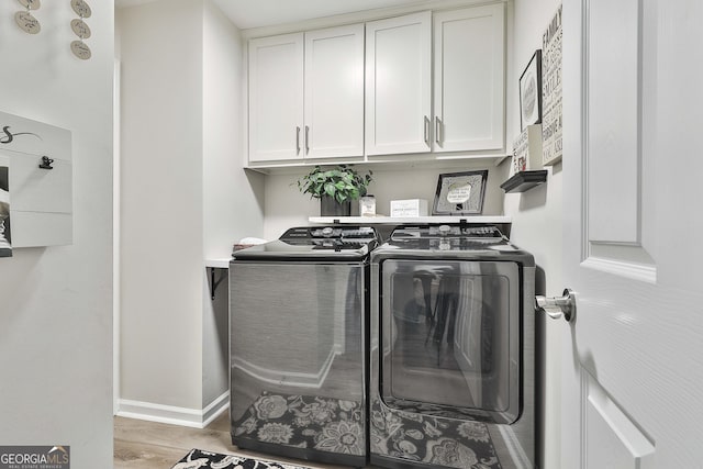 laundry room with cabinets, separate washer and dryer, and hardwood / wood-style floors