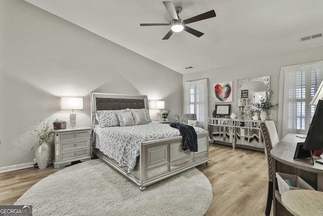 bedroom with ceiling fan, vaulted ceiling, and light wood-type flooring