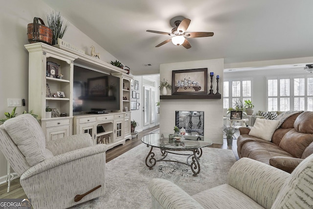 living room featuring ceiling fan, vaulted ceiling, and light hardwood / wood-style flooring