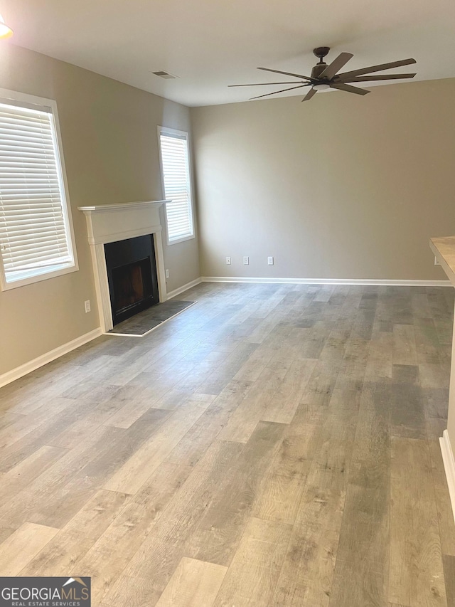 unfurnished living room featuring ceiling fan and light hardwood / wood-style floors