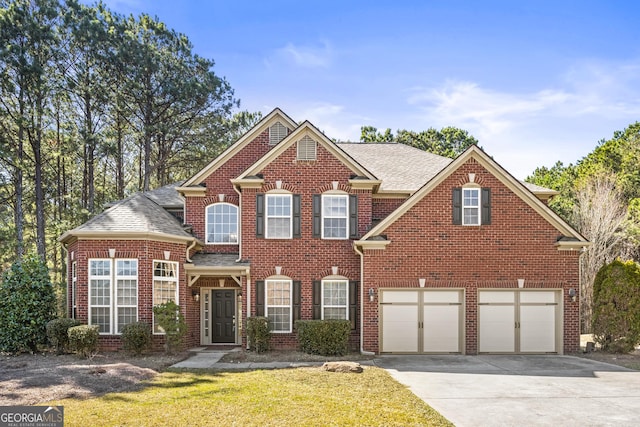 view of front facade with an attached garage, brick siding, a shingled roof, concrete driveway, and a front lawn