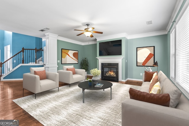 living room with stairs, ornate columns, wood finished floors, and a healthy amount of sunlight