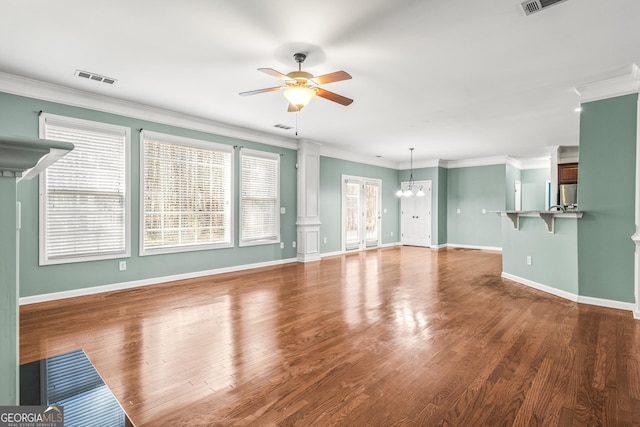 unfurnished living room with visible vents, ornamental molding, wood finished floors, baseboards, and ceiling fan with notable chandelier