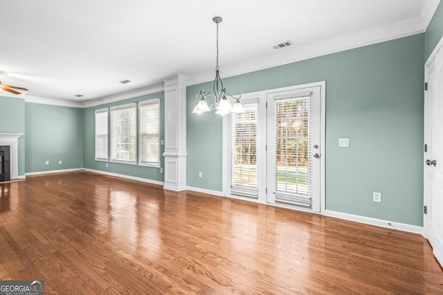 unfurnished living room featuring a fireplace, visible vents, wood finished floors, and ornamental molding