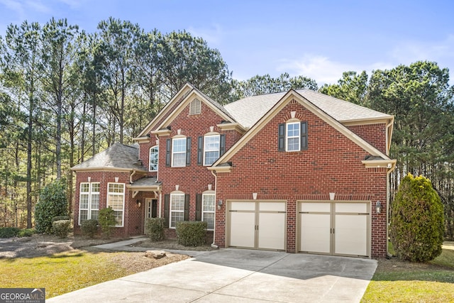 traditional-style house with a garage, driveway, brick siding, and a shingled roof