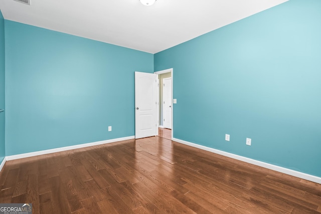 empty room with visible vents, baseboards, and wood finished floors