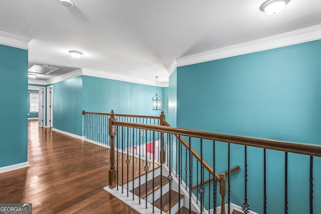 hall featuring ornamental molding, attic access, an upstairs landing, wood finished floors, and baseboards