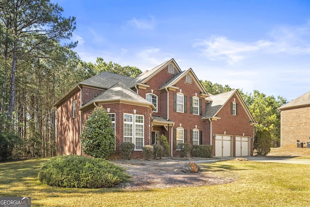 view of front facade featuring an attached garage, a front yard, concrete driveway, and brick siding