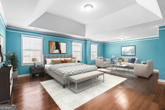 bedroom featuring dark wood-type flooring, visible vents, baseboards, ornamental molding, and a raised ceiling