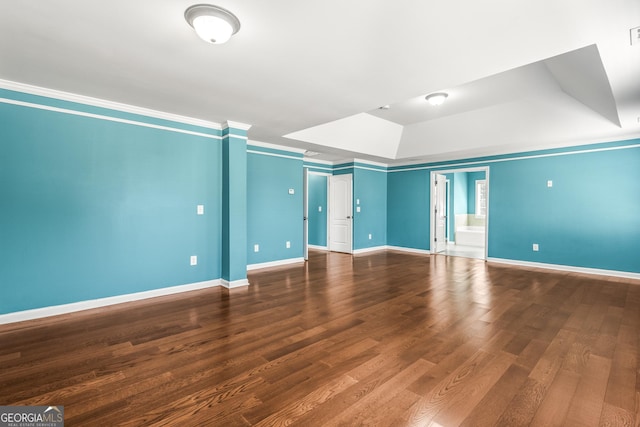 spare room with crown molding, baseboards, and wood finished floors