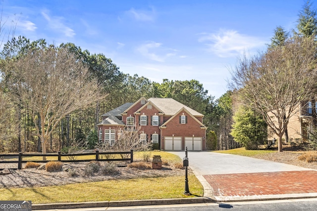 traditional-style house with a garage, brick siding, fence, and driveway