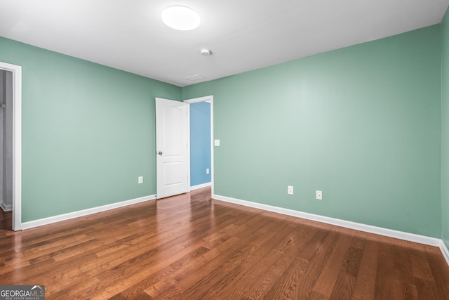 unfurnished bedroom with visible vents, baseboards, and wood finished floors