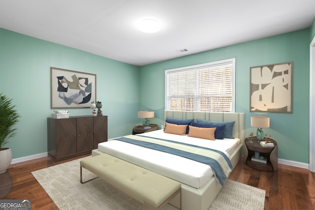 bedroom featuring visible vents, baseboards, and wood finished floors