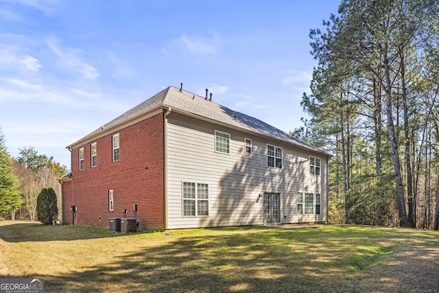 view of home's exterior with a yard, central AC unit, and brick siding