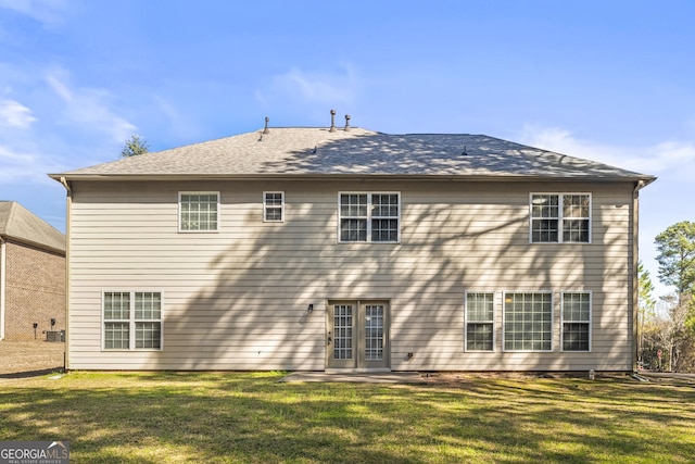 rear view of house with french doors and a yard