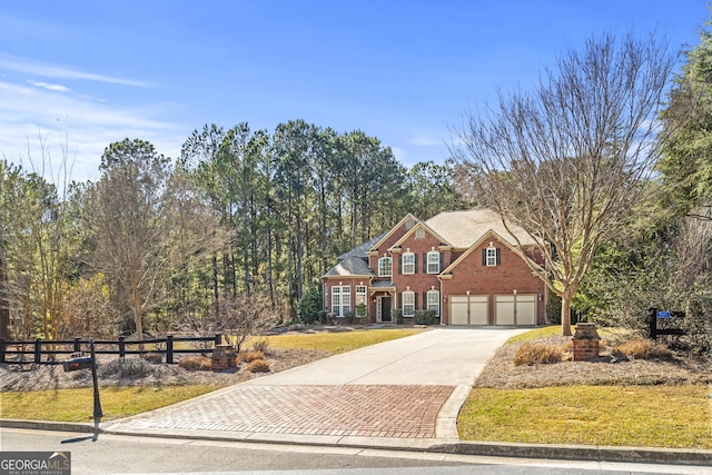 view of front facade featuring a garage, brick siding, fence, decorative driveway, and a front lawn