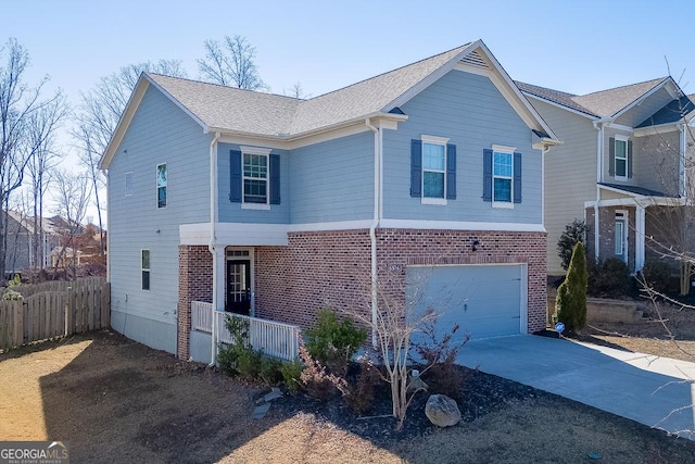 traditional home featuring a garage, brick siding, fence, concrete driveway, and roof with shingles