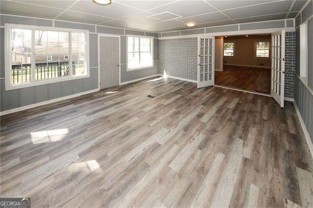 spare room with french doors, wood-type flooring, and a drop ceiling